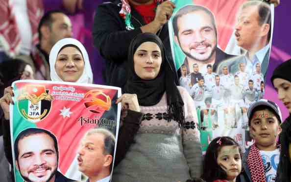 Jordanian fans holds a poster bearing po