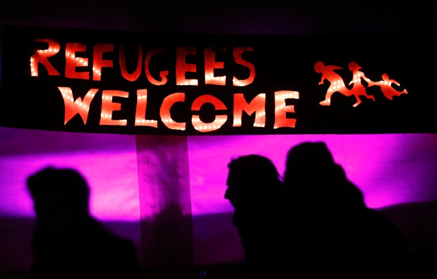 Counter protesters are silhouetted under a banner during a demonstration called by anti-immigration group PEGIDA in Dresden